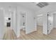 Bright hallway featuring modern wood flooring, white walls, and doorways to a bathroom and bedroom at 2105 Berkley Ave, Las Vegas, NV 89101