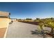Spacious backyard area with a gravel driveway and desert landscaping at 230 S Weeping Willow Ct, Pahrump, NV 89048