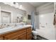 Well-lit bathroom with white cabinets, large mirror, and a shower-tub combination at 230 S Weeping Willow Ct, Pahrump, NV 89048