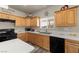 Well-lit kitchen with wood cabinets, white counter tops, and black appliances at 230 S Weeping Willow Ct, Pahrump, NV 89048
