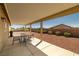 Covered patio featuring a dining set, with view of xeriscaped backyard at 230 S Weeping Willow Ct, Pahrump, NV 89048