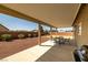 Covered patio featuring a dining set, with view of xeriscaped backyard at 230 S Weeping Willow Ct, Pahrump, NV 89048