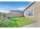 The backyard has artificial turf, a retaining wall, and some decorative plantings at 2383 Elmont Ave, North Las Vegas, NV 89086