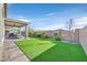Inviting backyard with lush artificial turf, covered patio, and well-maintained landscaping at 2383 Elmont Ave, North Las Vegas, NV 89086