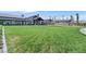Expansive green lawn leading up to a modern community clubhouse with covered outdoor seating areas at 2383 Elmont Ave, North Las Vegas, NV 89086