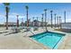 Community hot tub with tables, chairs, umbrellas, and palm trees under a sunny sky at 2383 Elmont Ave, North Las Vegas, NV 89086