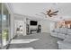 Spacious living room featuring plush carpet, ceiling fan, and sliding glass doors leading to the backyard at 2383 Elmont Ave, North Las Vegas, NV 89086