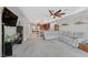 Open-concept living room with gray carpet, a ceiling fan, and views of kitchen at 2383 Elmont Ave, North Las Vegas, NV 89086