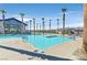 A luxurious community pool features a modern pool house, palm trees and inviting clear blue water at 2383 Elmont Ave, North Las Vegas, NV 89086