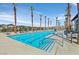 Community pool with clear blue water, palm trees, and lounge chairs for residents' relaxation at 2383 Elmont Ave, North Las Vegas, NV 89086