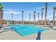 Community pool surrounded by palm trees and lounge chairs at 2383 Elmont Ave, North Las Vegas, NV 89086