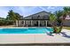 Lush backyard with sparkling pool, covered patio, and mature palm trees, perfect for relaxation at 2425 Greens Ave, Henderson, NV 89014