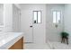 Bathroom featuring sleek walk-in shower with marble-style tile, window, and matching marble floor at 2425 Greens Ave, Henderson, NV 89014