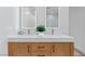 Bright bathroom featuring double sink vanity, quartz countertop, modern faucets, and lit mirrors at 2425 Greens Ave, Henderson, NV 89014