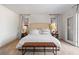 Neutral bedroom with a plush bed, stylish bench, and soft natural lighting at 2425 Greens Ave, Henderson, NV 89014