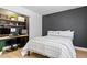 Modern bedroom with large bed, striped bedding, and built-in desk with dual computer monitors at 2425 Greens Ave, Henderson, NV 89014