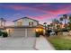 Charming home with a two-car garage and landscaped front yard at sunset at 2425 Greens Ave, Henderson, NV 89014