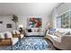 Open-concept living room with comfortable seating, bright natural light, and decorative rug at 2425 Greens Ave, Henderson, NV 89014