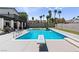 A backyard pool with a diving board is surrounded by palm trees and a concrete patio at 2425 Greens Ave, Henderson, NV 89014