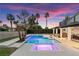 Backyard pool area featuring a luxurious pool and spa, landscaped yard, and outdoor dining space at 2425 Greens Ave, Henderson, NV 89014