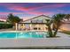 Inviting backyard pool with pristine water, mature palms, patio seating, and tranquil ambiance at 2425 Greens Ave, Henderson, NV 89014