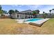 Stunning backyard oasis with a sparkling pool, lush lawn, and covered patio for relaxation at 2425 Greens Ave, Henderson, NV 89014