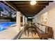 Inviting covered patio with outdoor seating and dining area overlooks the sparkling pool at 2425 Greens Ave, Henderson, NV 89014