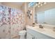 Bathroom with floral-patterned shower curtain, modern fixtures, and ample storage at 2509 Libretto Ave, Henderson, NV 89052