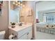 Bright bathroom leads into main bedroom, with white vanity and a decorative mirror at 2509 Libretto Ave, Henderson, NV 89052
