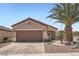 Charming single-story home with a two-car garage, desert landscaping, and a palm tree at 2509 Libretto Ave, Henderson, NV 89052