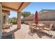 Covered patio is furnished with dining table and seating set against brick paved floor at 2509 Libretto Ave, Henderson, NV 89052