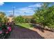 Landscaped backyard featuring lush greenery, flowering bushes, and a tranquil pebble ground cover at 2554 Braehead Ln, Henderson, NV 89044