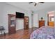 Bedroom featuring a large TV, display cases, and wood flooring, blending comfort and entertainment at 2554 Braehead Ln, Henderson, NV 89044