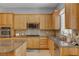 Kitchen features wooden cabinetry, stainless steel appliances, and granite countertops at 2554 Braehead Ln, Henderson, NV 89044