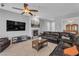 Well-lit living room with a cozy fireplace, fan, and entertainment center at 2554 Braehead Ln, Henderson, NV 89044
