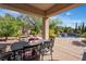 Covered patio area with an outdoor dining set and views of a pool and lush landscaping at 2554 Braehead Ln, Henderson, NV 89044