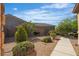 Backyard featuring rock landscaping, lush bushes, and a well-kept lawn at 2554 Braehead Ln, Henderson, NV 89044