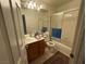 Small bathroom with vanity, mirror, toilet, and tub shower combination with sliding glass doors at 2571 Swans Chance Ave, Henderson, NV 89052