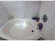 Close-up of a built-in white bathtub with white tile surround and chrome fixtures at 2571 Swans Chance Ave, Henderson, NV 89052