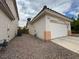 Tan home featuring a two car garage, gravel yard, and an orange tiled roof at 2571 Swans Chance Ave, Henderson, NV 89052