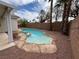 Kidney-shaped pool with an attached hot tub surrounded by rock landscaping in backyard at 2571 Swans Chance Ave, Henderson, NV 89052