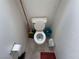 A high-angle shot of a small, cramped toilet with tile floor and cleaning supplies at 2571 Swans Chance Ave, Henderson, NV 89052