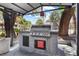 Community outdoor grill area with stainless steel grill, mature trees, and covered shelter at 2606 S Durango Dr # 260, Las Vegas, NV 89117