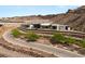 A modern home is nestled into its desert hillside with well-maintained roads and landscaping at 3 Horseshoe Rock Ct, Henderson, NV 89012