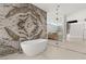 Elegant bathroom with soaking tub, marble accent wall, and seamless glass shower enclosure at 3 Horseshoe Rock Ct, Henderson, NV 89012