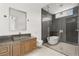 Bright bathroom featuring a vessel sink, wood cabinets, and a glass-enclosed shower and tub at 3 Horseshoe Rock Ct, Henderson, NV 89012