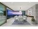 Modern dining room features a long table, fireplace and sliding glass doors opening to an outdoor seating area with city views at 3 Horseshoe Rock Ct, Henderson, NV 89012