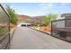 Gated driveway leading to a modern home with a striking rock facade and mountain backdrop at 3 Horseshoe Rock Ct, Henderson, NV 89012