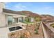 Modern home's exterior featuring a sleek fountain, xeriscaping, and panoramic views of the desert landscape at 3 Horseshoe Rock Ct, Henderson, NV 89012