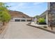 Three-car garage and modern exterior, showcasing desert landscaping and a concrete driveway at 3 Horseshoe Rock Ct, Henderson, NV 89012